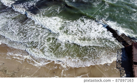 Aerial drone view flight over waves that roll onto the sandy shore. Top view 87897163