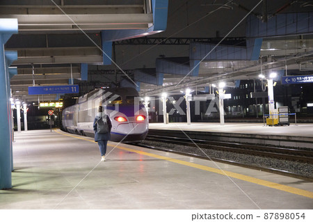 Train leaving railway station platform 87898054