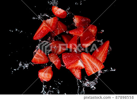 Freeze motion of sliced strawberries in water splash. Freeze motion of sliced strawberries in water splash. 87898558