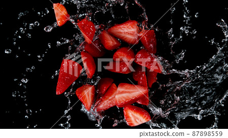 Freeze motion of sliced strawberries in water splash. 87898559