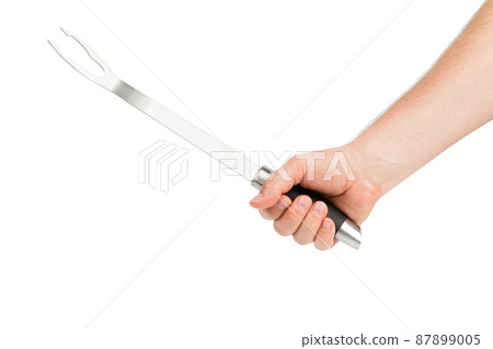 A hand holds a barbecue fork. A hand holds a barbecue fork. 87899005