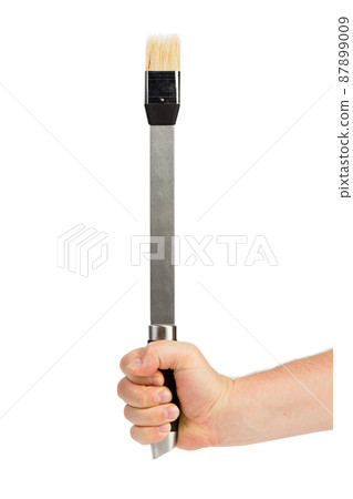 A hand holds a basting brush. A hand holds a basting brush. 87899009