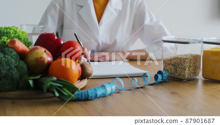 Nutritionist giving consultation to patient with healthy fruit and vegetable, Right nutrition and diet concept. 87901687