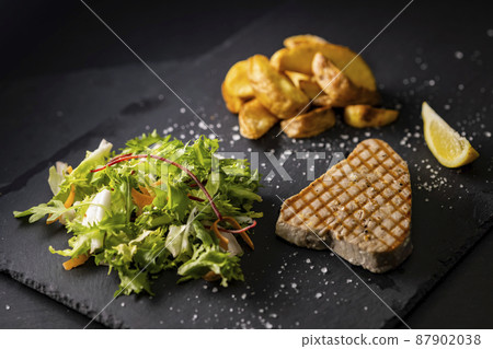 tuna steak with salad and spicy potatoes 87902038