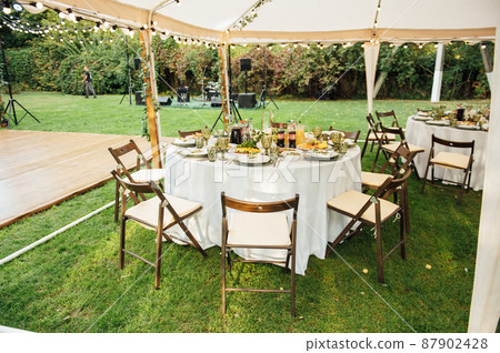 Wedding. Banquet. The chairs and round table for guests, served with cutlery. Wedding. Banquet. The chairs and round table for guests, served with cutlery. 87902428