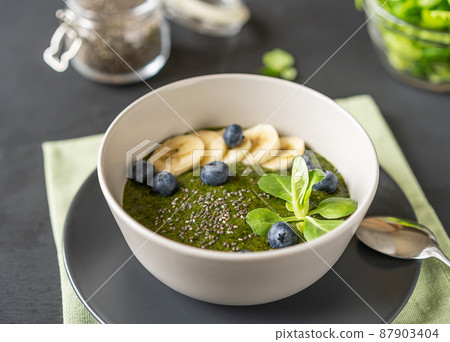 Smoothie or green porridge mad with greens, soaked chia seeds and banana as a sweetener Smoothie or green porridge mad with greens, soaked chia seeds and banana as a sweetener 87903404