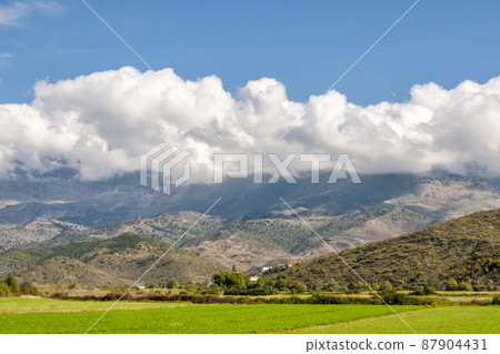 Beautiful mountain valley with gentle hills and agricultutal filds 87904431