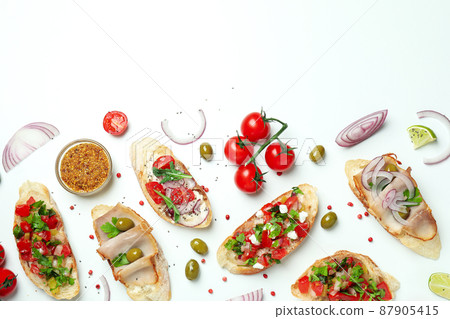 Delicious italian snacks bruschetta and ingredients on white background Delicious italian snacks bruschetta and ingredients on white background 87905415