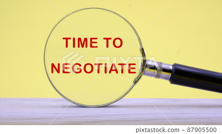 time to negotiate text on a yellow background through a magnifying glass time to negotiate text on a yellow background through a magnifying glass 87905500