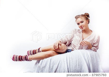 young pretty blond woman laying in bed isolated on white background, lifestyle people concept 87905760