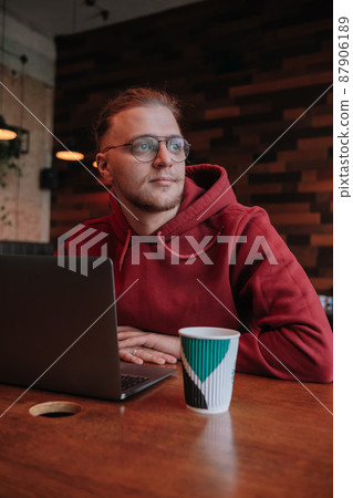 Portrait of happy male freelancer in optical eyewear for vision correction smiling at camera during break from web working online, cheerful hipster blogger sitting in cafe with mockup laptop Portrait of happy male freelancer in optical eyewear for vision correction smiling at camera during break from web working online, cheerful hipster blogger sitting in cafe with mockup laptop 87906189