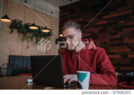 Portrait of happy male freelancer in optical eyewear for vision correction smiling at camera during break from web working online, cheerful hipster blogger sitting in cafe with mockup laptop 87906205