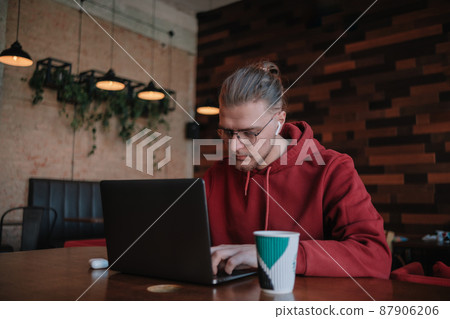 Portrait of happy male freelancer in optical eyewear for vision correction smiling at camera during break from web working online, cheerful hipster blogger sitting in cafe with mockup laptop 87906206