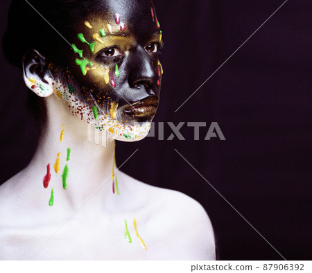 woman with creative makeup closeup like drops of colors, facepaint close up halloween 87906392