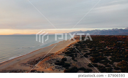 Aerial view of seashore in Tuscany with mountain range and autumn vegetation. 87906593
