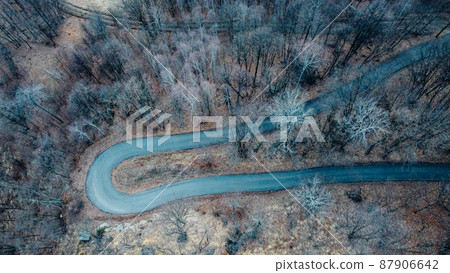 Narrow road in misty forest, aerial view. Narrow road in misty forest, aerial view. 87906642