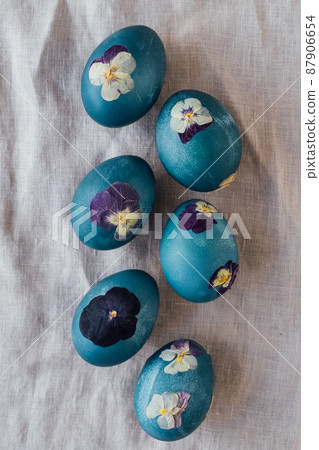 Pressed flower Easter eggs on beige tablecloth. Pressed flower Easter eggs on beige tablecloth. 87906654