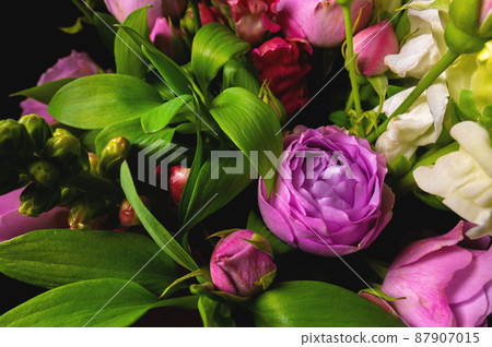 Fresh mixed flower bouquet on black background. Green branches with rich peony roses. Dark floral background Fresh mixed flower bouquet on black background. Green branches with rich peony roses. Dark floral background 87907015
