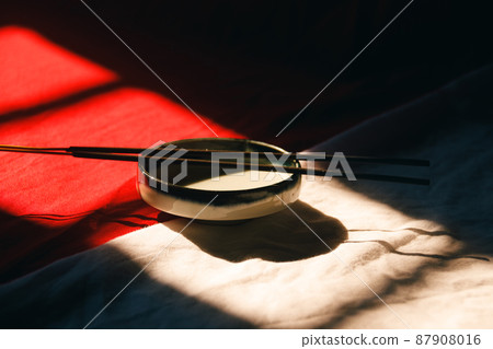 Light and shadows cast on a ceramic incense holder and sticks showing zen, wellness and mindfulness Light and shadows cast on a ceramic incense holder and sticks showing zen, wellness and mindfulness 87908016