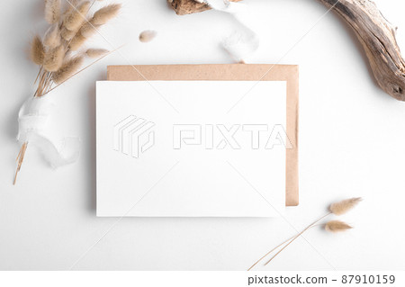 Wedding stationery invitation card mockup 7x5 on white background with envelop and boho decor Wedding stationery invitation card mockup 7x5 on white background with envelop and boho decor 87910159