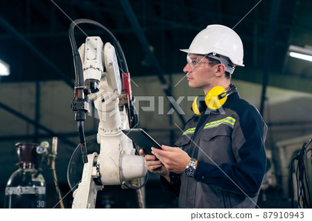 Young factory worker working with adept robotic arm Young factory worker working with adept robotic arm 87910943
