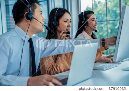 Business people wearing headset working actively in office Business people wearing headset working actively in office 87910983