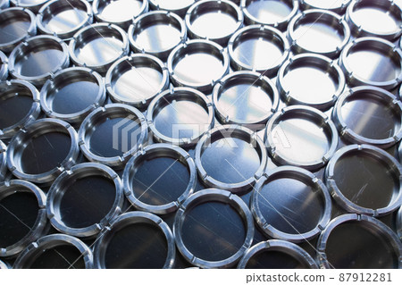 shiny metal rings after turning and milling, silver colored parts on flat steel surface close-up full frame background 87912281