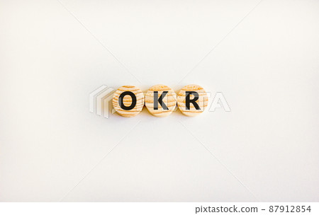 OKR, objectives and key results symbol. Concept words OKR objectives and key results on wooden circles on a beautiful white background. Business OKR objectives and key results concept. Copy space. OKR, objectives and key results symbol. Concept words OKR objectives and key results on wooden circles on a beautiful white background. Business OKR objectives and key results concept. Copy space. 87912854