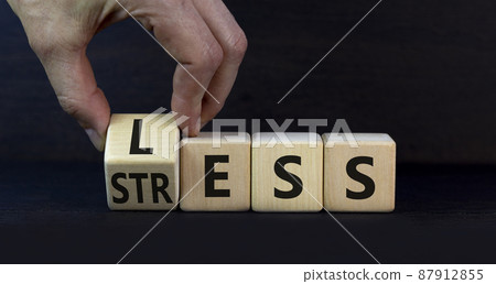 Having less stress or being stress-less symbol. Doctor turns a wooden cube and changes the concept word Stress to Less. Beautiful grey table grey background, copy space. Less stress concept. 87912855