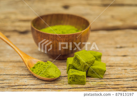 Matcha powder and candy made of matcha on wooden background. Homemade Matcha Matcha powder and candy made of matcha on wooden background. Homemade Matcha 87913197