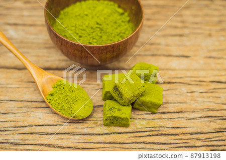 Matcha powder and candy made of matcha on wooden background. Homemade Matcha Matcha powder and candy made of matcha on wooden background. Homemade Matcha 87913198