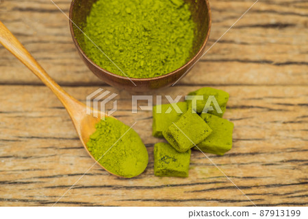 Matcha powder and candy made of matcha on wooden background. Homemade Matcha Matcha powder and candy made of matcha on wooden background. Homemade Matcha 87913199
