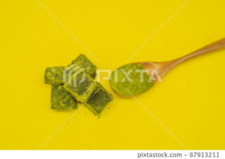 Spoon with matcha powder and candy made of matcha on yellow background. Homemade Matcha Spoon with matcha powder and candy made of matcha on yellow background. Homemade Matcha 87913211