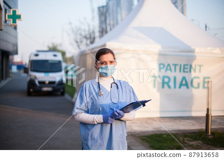 Portrait of serious female key front line worker in blue PPE uniform 87913658