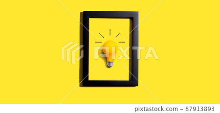 Yellow light bulb inside a frame - inspiration, creativity themes 87913893