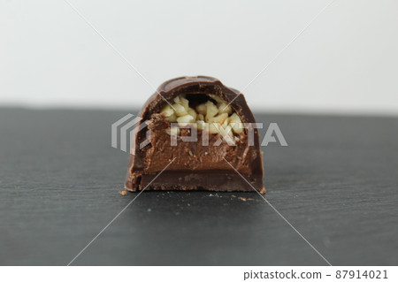 incision chocolate case candy stuffed with chocolate pralines and crushed peanuts close-up on a gray background with space for copyspace text. Chocolate Day Sweet Homemade Desserts incision chocolate case candy stuffed with chocolate pralines and crushed peanuts close-up on a gray background with space for copyspace text. Chocolate Day Sweet Homemade Desserts 87914021