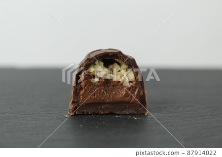 incision chocolate case candy stuffed with chocolate pralines and crushed peanuts close-up on a gray background with space for copyspace text. Chocolate Day Sweet Homemade Desserts incision chocolate case candy stuffed with chocolate pralines and crushed peanuts close-up on a gray background with space for copyspace text. Chocolate Day Sweet Homemade Desserts 87914022