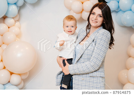 happy mom and son in front of the photo zone with balloons happy mom and son in front of the photo zone with balloons 87914875
