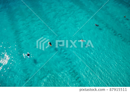 Surfers in transparent ocean waiting wave. Aerial view 87915511