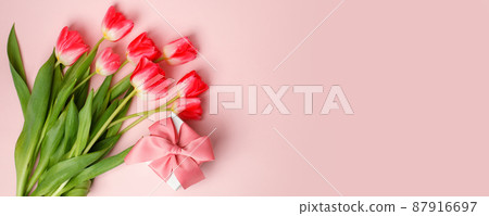 Gift or present box, tulips on pink table top view. Flatlay composition for birthday, mother day, saint Valentine day, wedding. Flyer, invitation, banner for your site, greeting card with copyspace 87916697