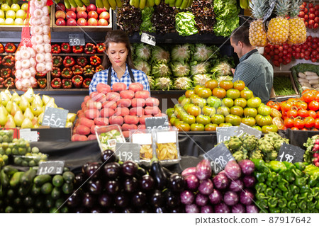 Posing adult woman and working man in fruit shop 87917642