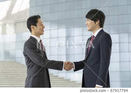 Business scene: Two businessmen shaking hands 87917794