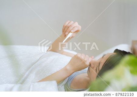 A woman who measures body temperature A woman who measures body temperature 87922110