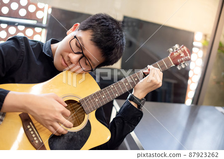 Asian man guitarist playing music with guitar Asian man guitarist playing music with guitar 87923262