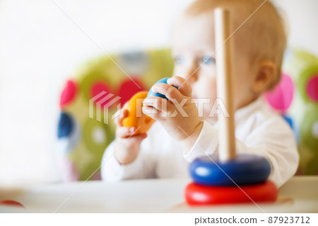 the kid plays the pyramid. child playing with wooden toys the kid plays the pyramid. child playing with wooden toys 87923712