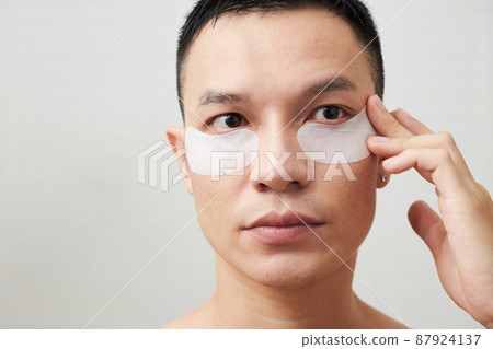 Man Applying Collagen Patches Man Applying Collagen Patches 87924137