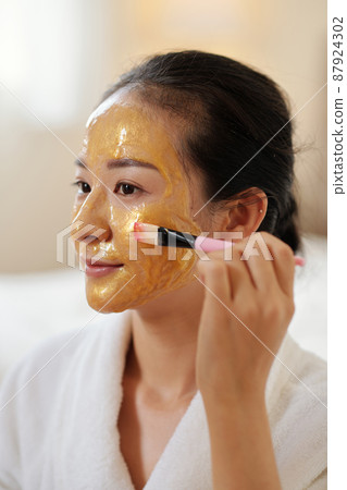 Woman Applying Smoothing Face Mask Woman Applying Smoothing Face Mask 87924302