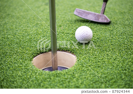 Golf ball and golf club on artificial grass. Golf ball and golf club on artificial grass. 87924344