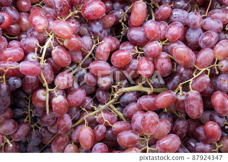 Bunch of colorful grapes with leaves 87924347