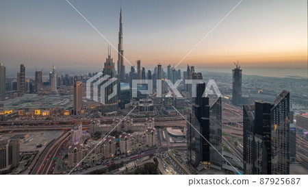 Aerial view of tallest towers in Dubai Downtown skyline and highway day to night timelapse. Aerial view of tallest towers in Dubai Downtown skyline and highway day to night timelapse. 87925687
